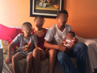 family sitting on couch with faces blurred