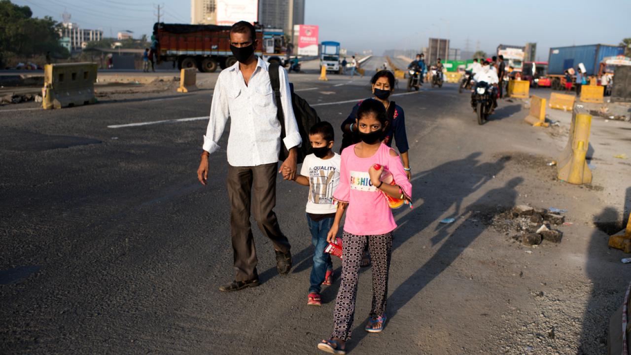 Migrants walking home from work with masks