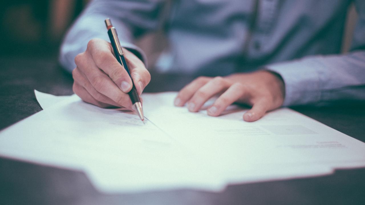 person writing on papers