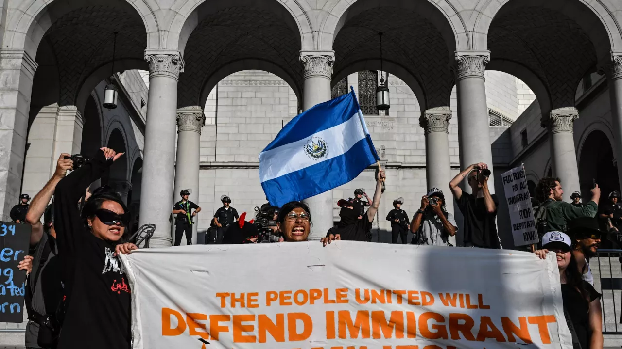 A protester waves a Salvadoran flag as people protest in front of Los Angeles City Hall against federal immigration operations on June 11, 2025. Protests against Donald Trump's harsh immigration policies spread on June 11 across the United States.