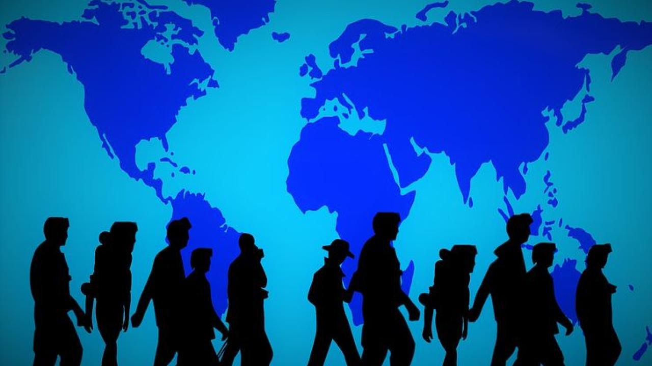 Image of people walking with a map of the world in the background.