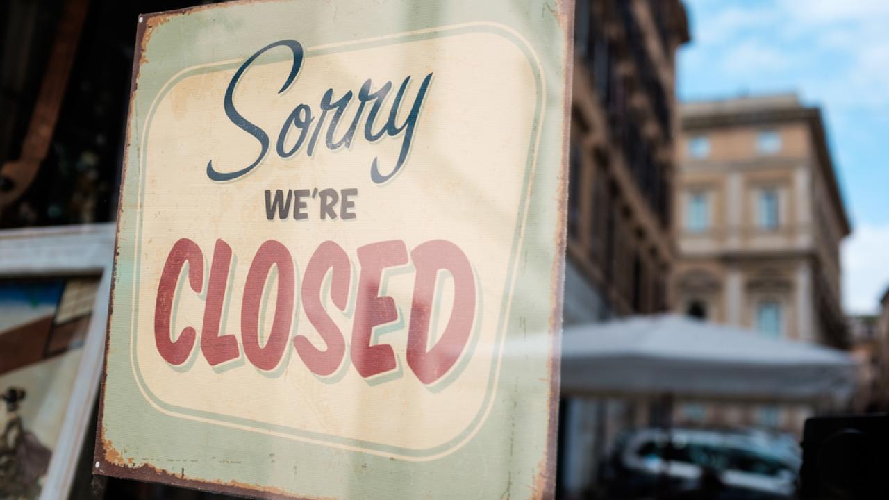 Sign on shop door that reads "Sorry We're Closed"